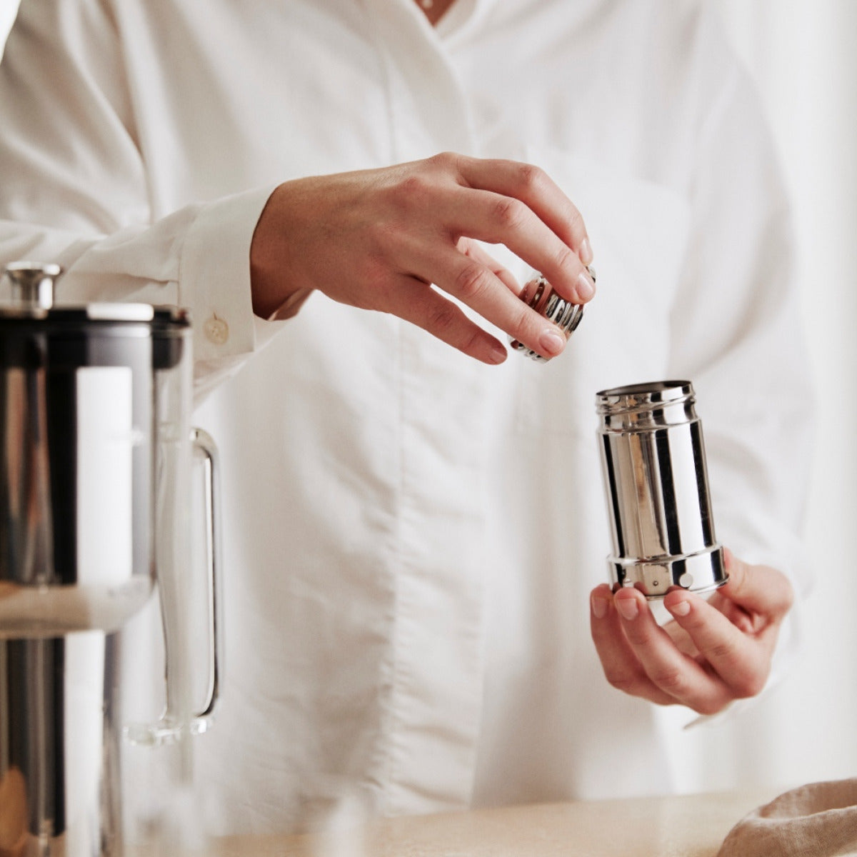 A woman refills the granules for the Aarke Water Purifier Pitcher.