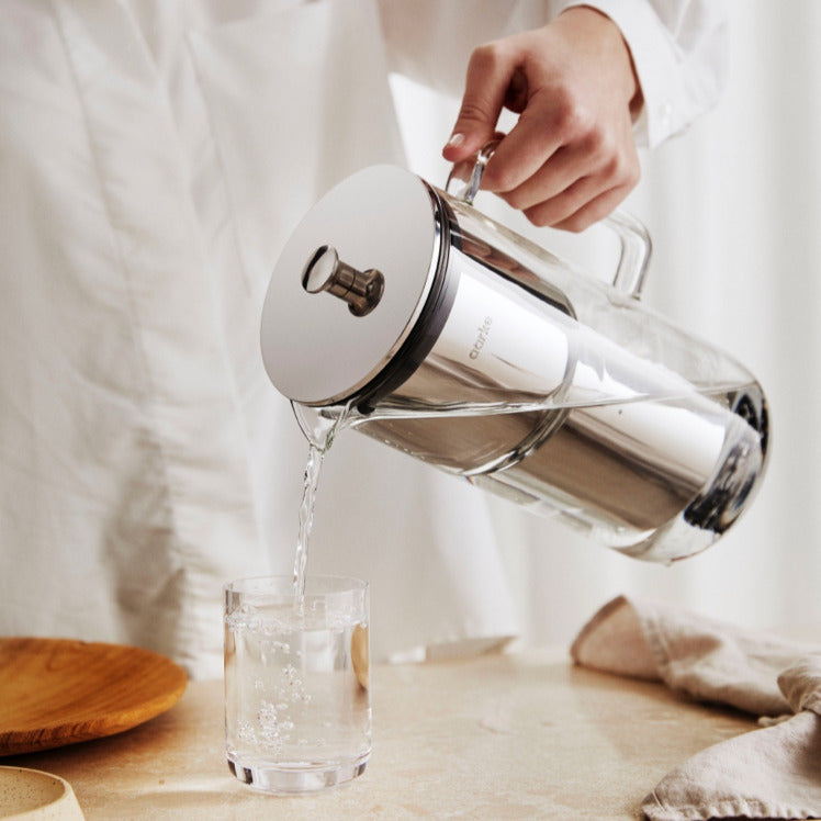 Someone pours a glass of water from the Aarke Purifier.
