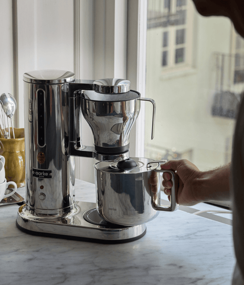 Aarke stainless steel coffee maker brewing coffee directly into the matching Aarke thermal jug.
