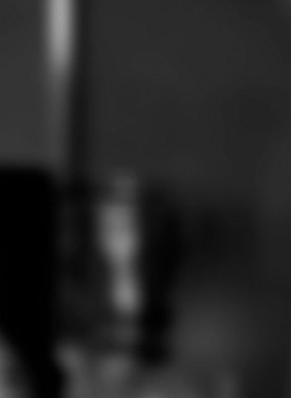 Blurred black and white image of a person holding a smartphone.