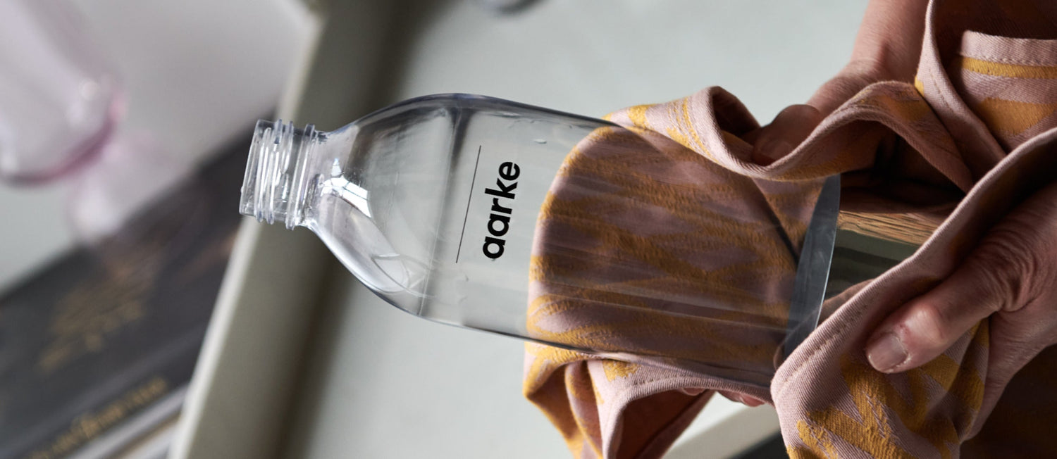 A person holds a PET Bottle in a cloth.