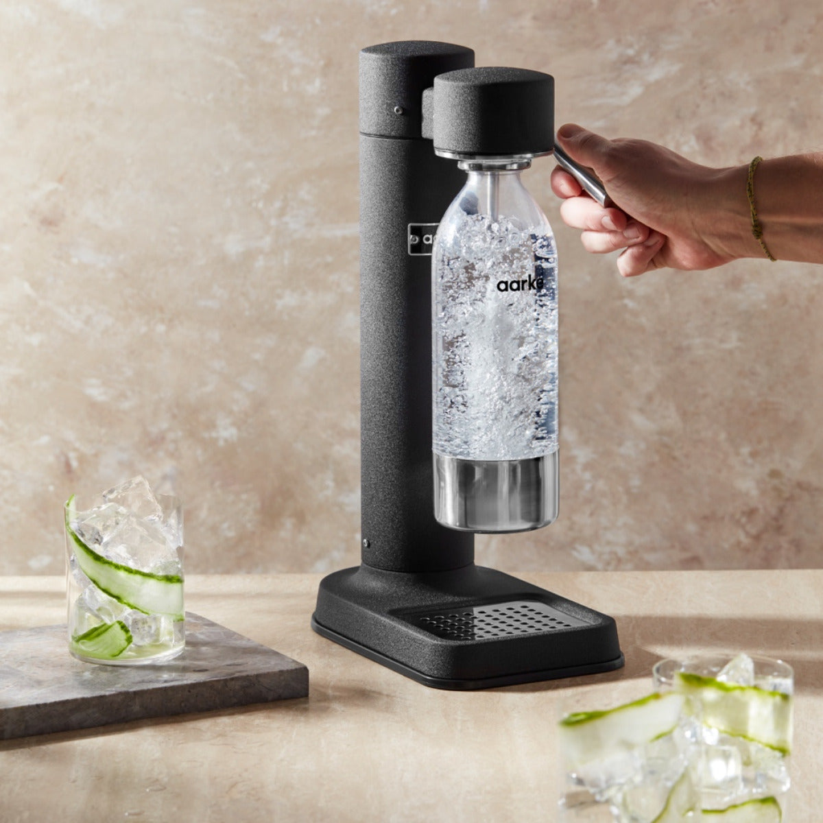 A person carbonating water with the Aarke Carbonator 3 in Matte Black.