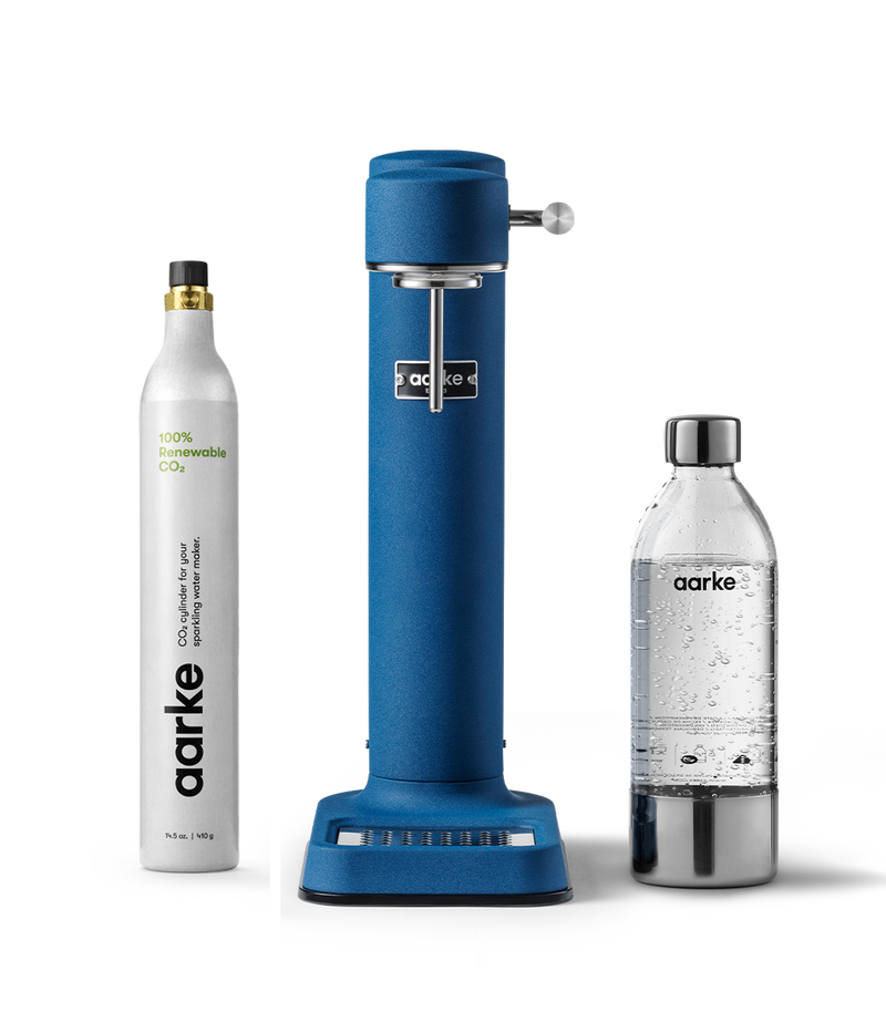 Front view of the Carbonator 3 in Cobalt Blue beside a PET water bottle and 1 Aarke CO2 Cylinder.
