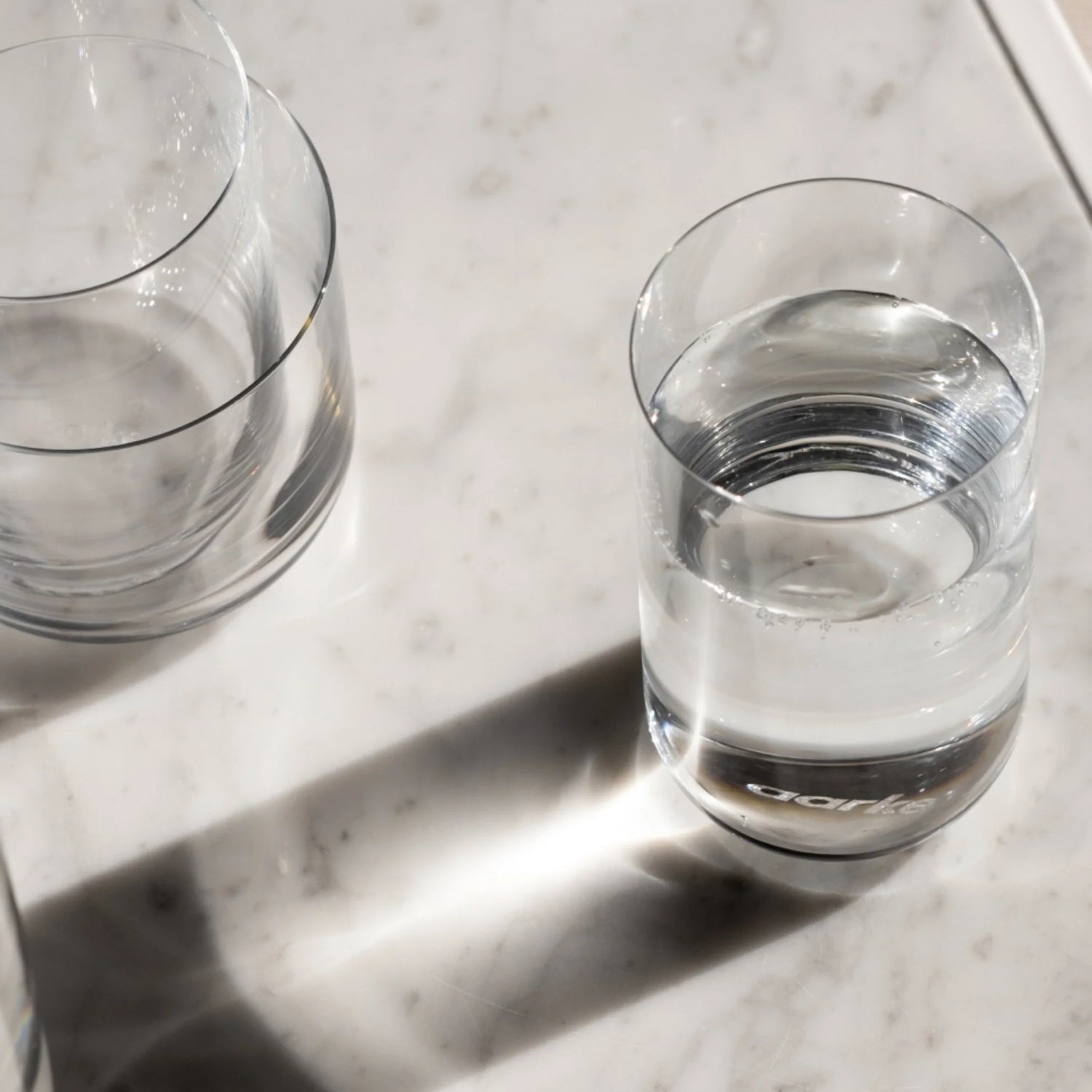 Aarke Glassware nesting glasses set on a table with water inside.