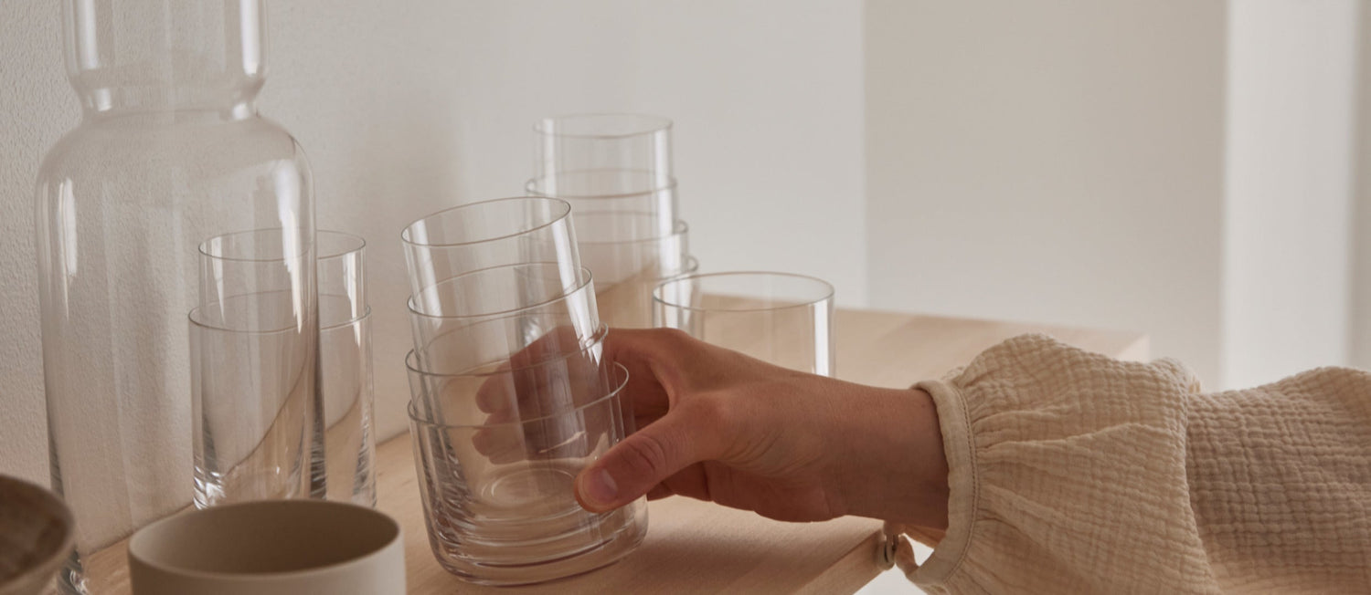 Someone picks up a set of Aarke Nesting Glasses from a shelf.