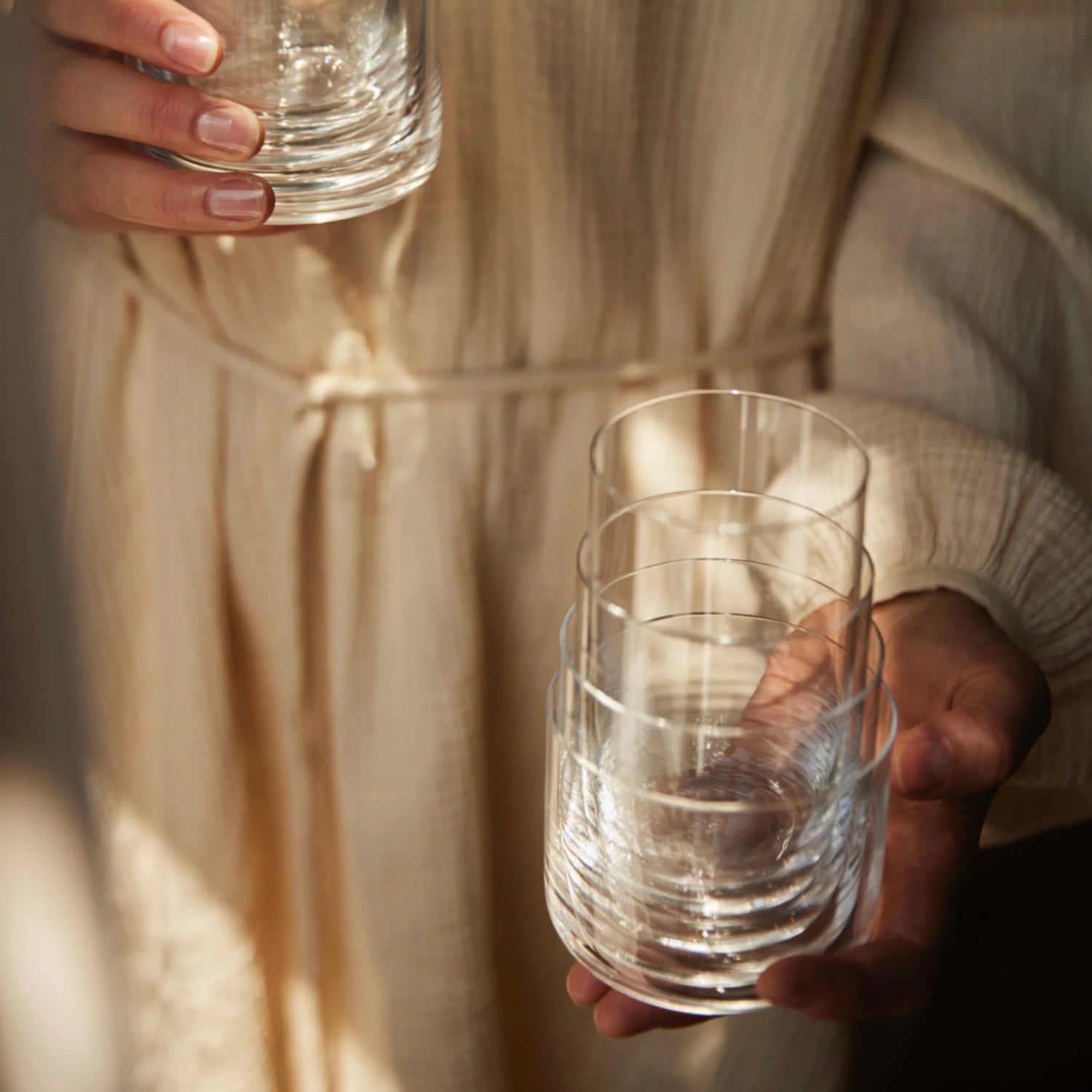 A person holding the Aarke Glassware nesting set.