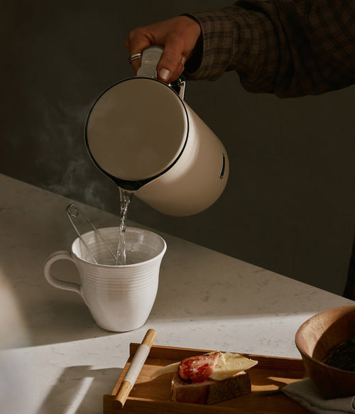 AARKE Kettle Sand electric kettle pouring hot water into a ceramic cup, showcasing precision spout and modern design.