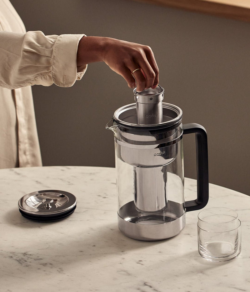 A person inserting the stainless steel cartridge into the Aarke Purifier Large.