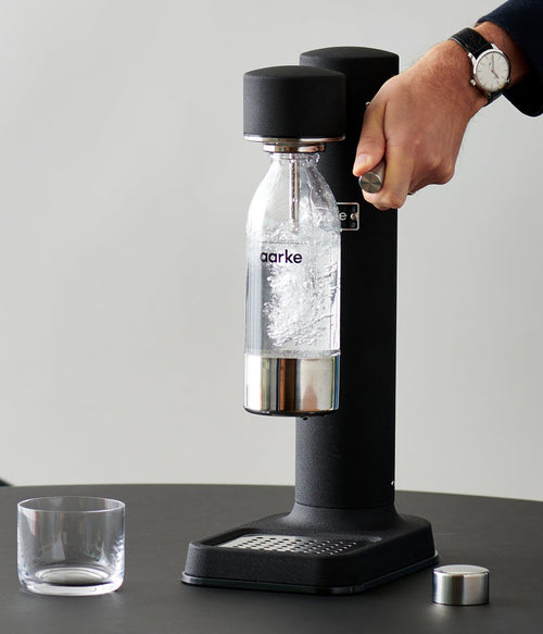 Person using Matte Black Carbonator 3, as PET bottle fills with bubbles.