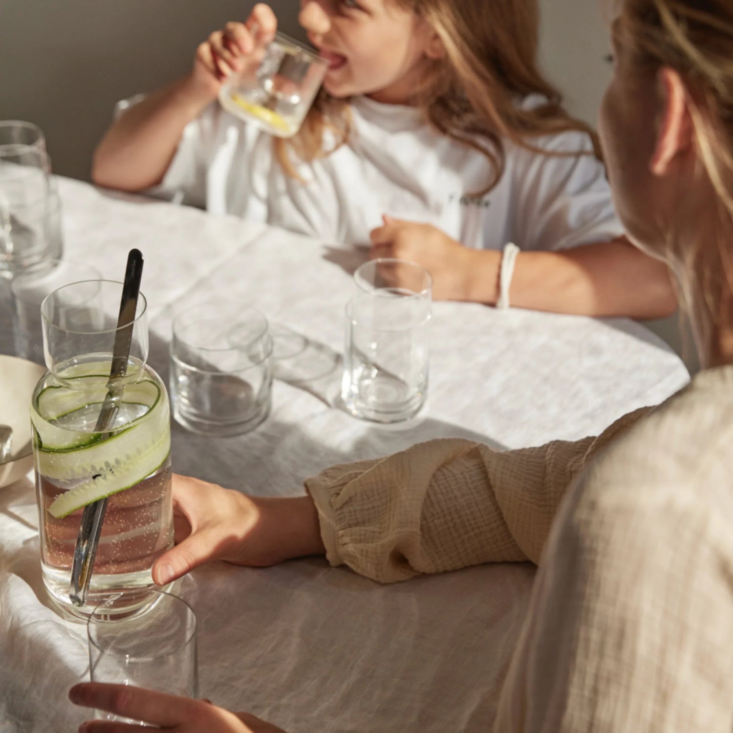 A family sits at a table using Aarke Glassware