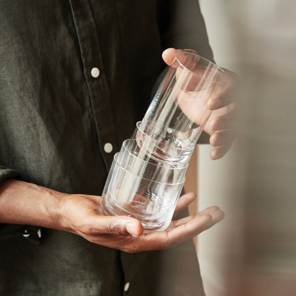 A man holds a stack of Aarke Nesting Glasses.