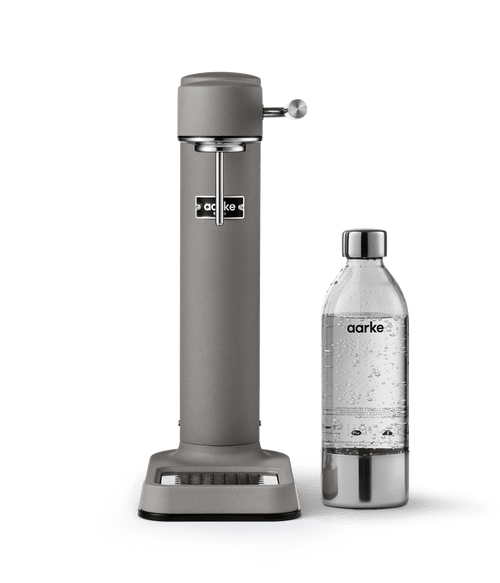 Front view of the Matte Grey Aarke Carbonator 3 paired with a PET bottle filled with sparkling water.