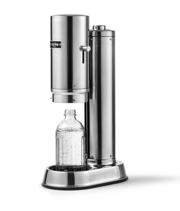 Aarke Carbonator Pro in Stainless Steel. Side view with chamber open and Glass Bottle sitting inside.