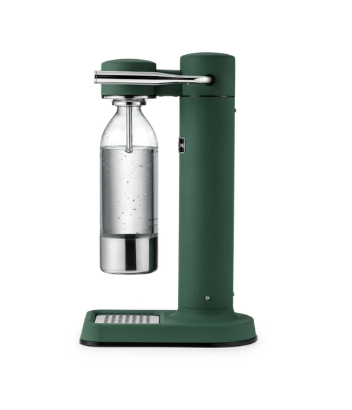 Aarke Carbonator 3 in Heritage Green with a stainless steel and glass bottle filled with sparkling water.