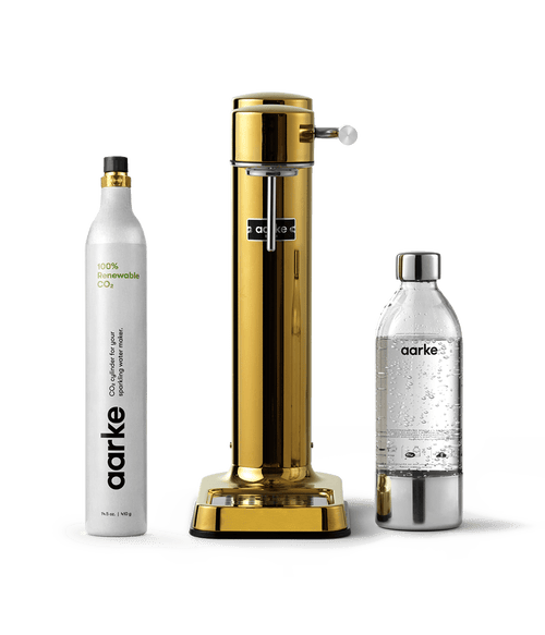 Front view of the Carbonator 3 in Gold beside a PET water bottle and a CO2 Cylinder.