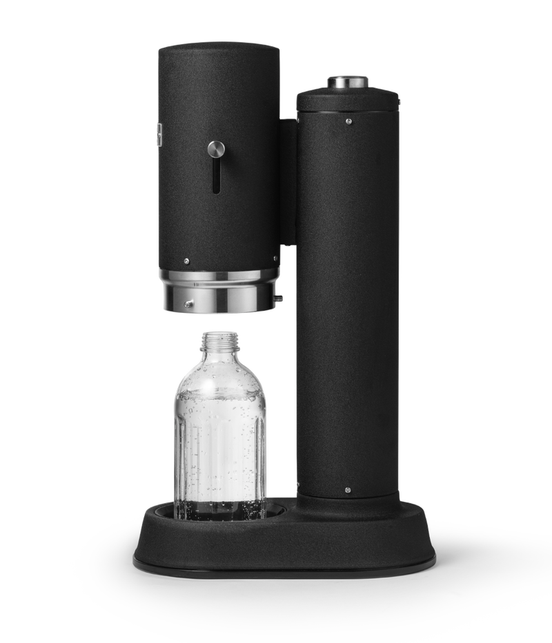 Aarke Carbonator Pro in Matte Black. Side view with chamber open and Glass Bottle sitting inside.